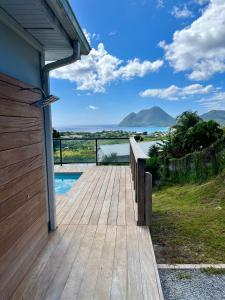 a wooden deck with a view of the water at La villa O'rizon in Le Diamant