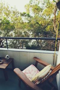a rocking chair on a balcony with a table at Riversong Perth in Perth