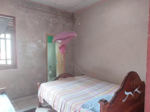 a bedroom with a bed with a pink umbrella at Green Waves HomeStay in Nonagegama