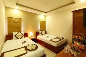Ένα ή περισσότερα κρεβάτια σε δωμάτιο στο Kingdom Danang Hotel