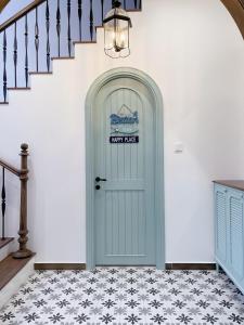 a blue door in a hallway with a staircase at Seamoni Seaview Villa 01 - Novaworld Phan Thiết in Phan Thiet