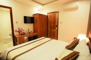 Ένα ή περισσότερα κρεβάτια σε δωμάτιο στο Kingdom Danang Hotel