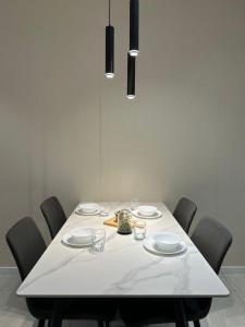 a table with chairs and a white table cloth at Quill Residence KLCC By Ezhome in Kuala Lumpur