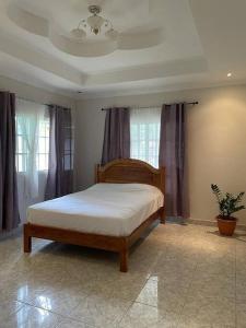 a bedroom with a bed in a room with windows at Tu casa en Macaracas! in Llano de Piedra