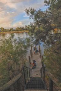 un groupe de personnes assises sur un quai sur une rivière dans l'établissement Riversong Perth, à Perth