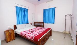 1 dormitorio con 1 cama grande y cortinas azules en Blooms home stay, en Thekkady