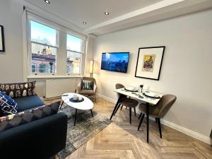 ein Wohnzimmer mit einem Sofa und einem Tisch in der Unterkunft Chiltern Street Serviced Apartments - Marylebone in London