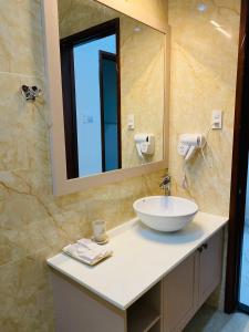 een badkamer met een wastafel en een spiegel bij N'Queen Villa in Da Lat