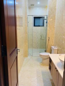 een badkamer met een douche, een toilet en een wastafel bij N'Queen Villa in Da Lat