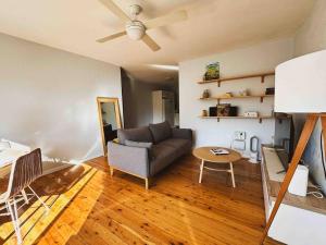 a living room with a couch and a table at Harbourside Bliss: 2-Bedroom Coastal Apartment in Wollongong