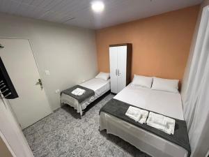 - une petite chambre avec 2 lits et une porte dans l'établissement Suites Mar Azul, à São José da Coroa Grande