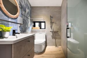 un bagno con un water, un lavandino e uno specchio di Donggang Jingdi B&B a Donggang