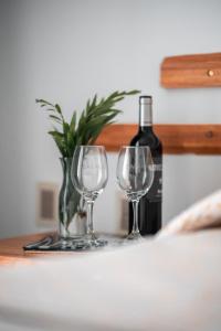 a bottle of wine and two wine glasses on a table at BARAKA - Posada in Piriápolis