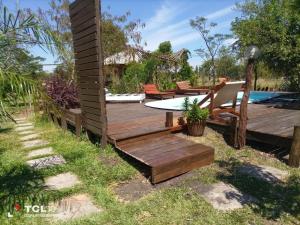 El Mangrullo في فيديراسيون: سطح خشبي مع طاولة وكراسي بجوار حمام سباحة