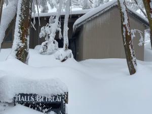 a building covered in snow with a sign that reads halls natural at Halls Retreat - Luxury with a spa in Baw Baw Village