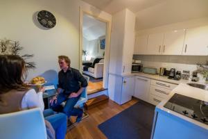 a man standing in a kitchen with a group of people at Halls Retreat - Luxury with a spa in Baw Baw Village