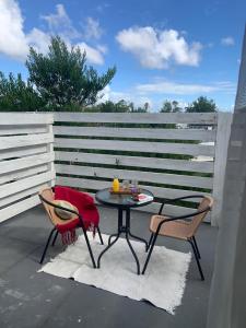 een patio met een tafel en stoelen en een hek bij BARAKA - Posada in Piriápolis