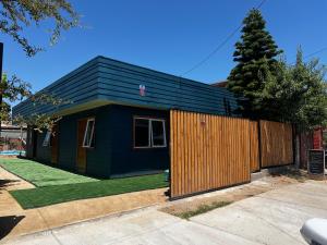 a small house with a black roof and a fence at Alojamiento Rustico Belloto (2) in Quilpué