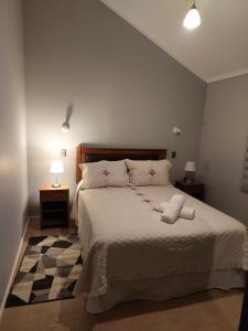 a bedroom with a bed with a white bedspread at Casa Isabella in Puerto Natales