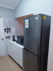 um frigorífico de aço inoxidável numa cozinha com um micro-ondas em Casa Isabella em Puerto Natales