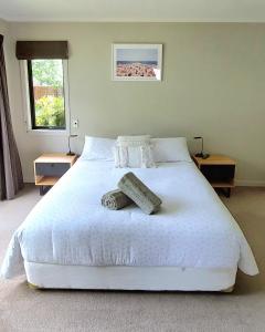 a bedroom with a white bed with two towels on it at Private guest room - no kitchen in Wanaka