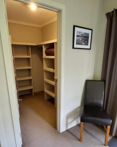 a door to a closet with a chair in a room at Private guest room - no kitchen in Wanaka