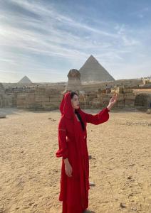 a woman is standing in front of the pyramids at LOAY PYRAMIDS VIEW in Cairo