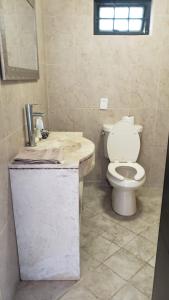 a bathroom with a white toilet and a sink at Cabaña de lujo con Terraza para eventos in San José del Puente