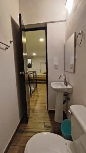 baño con aseo y lavamanos y pasillo en Departamento loft súper ubicado. en Orizaba