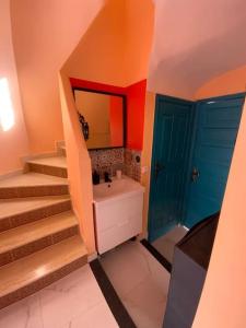 ein Badezimmer mit einer Treppe, einem Waschbecken und einem Spiegel in der Unterkunft Spacious 3-Floor Riad in Marrakesch