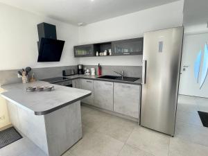 eine Küche mit einem großen Kühlschrank aus Edelstahl in der Unterkunft Maison Brem, 4 pièces, 6 personnes - FR-1-231-297 in Brem Sur Mer