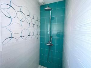 un bagno con doccia con piastrelle blu di Maison familiale récente avec jardin, plage et commerces à pied, 6 couchages, WIFI, parking privatif - FR-1-231-297 a Brem-sur-Mer Altre 15 foto