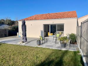 una casa con patio e ombrellone di Maison familiale récente avec jardin, plage et commerces à pied, 6 couchages, WIFI, parking privatif - FR-1-231-297 a Brem-sur-Mer
