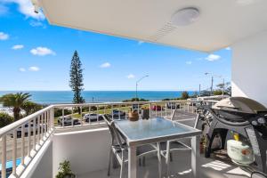 亚历山德拉岬角Newly renovated beach front unit. Views to die for!的带桌子的阳台，可欣赏海景