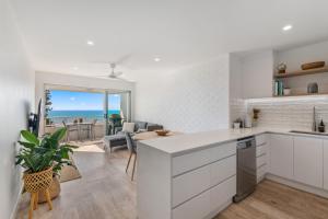 cocina y sala de estar con vistas al océano en Newly renovated beach front unit. Views to die for!, en Alexandra Headland