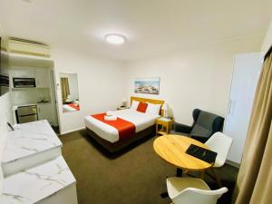 a hotel room with a bed and a desk at Colonial Lodge Motor Inn in Yass