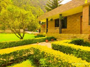 una casa con un jardín de flores amarillas en Casas vacacionales Baños, en Baños