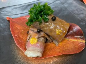 un plato de comida con un trozo de carne y hortalizas en おばな旅館 富貴亭, 