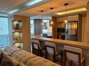 cocina y sala de estar con barra con sillas en Beira Mar com Excelente Localização, en Balneário Camboriú