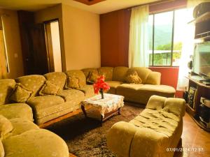 sala de estar con sofá grande y mesa en Casas vacacionales Baños, en Baños