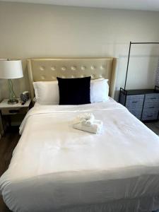 Una gran cama blanca con un par de zapatos. en Guest House next to Little Italy, en San Diego