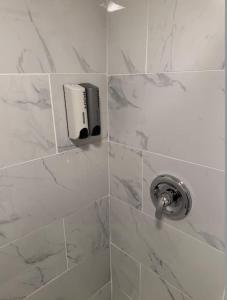 una ducha con dispensador de jabón en una pared de azulejos en Guest House next to Little Italy, en San Diego