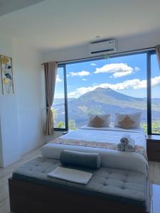 a bedroom with a bed with a large window at Devanora Hotel & Resto in Kintamani