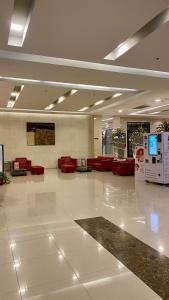 a large lobby with red chairs and a white floor at Sukhumvit13 Luxury suite in Bangkok