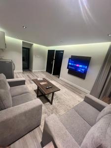 - un salon avec deux canapés et une télévision à écran plat dans l'établissement Amwaj Alshatie Furnished Units, à Dammam