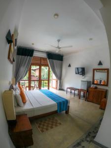 a bedroom with a bed and a large window at Hotel Athgira in Udawalawe