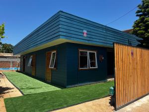 uma pequena casa azul com um jardim verde em Alojamiento rústico Belloto (3) em Quilpué