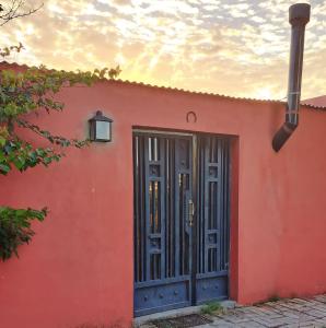 uma casa vermelha com uma porta e um pôr-do-sol em El Potrero Casa de Campo em Arana