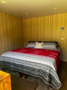 uma cama num quarto com paredes de madeira em Alojamiento rústico Belloto (3) em Quilpué