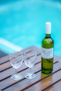 a bottle of wine and two wine glasses on a table at Hotel Athgira in Udawalawe